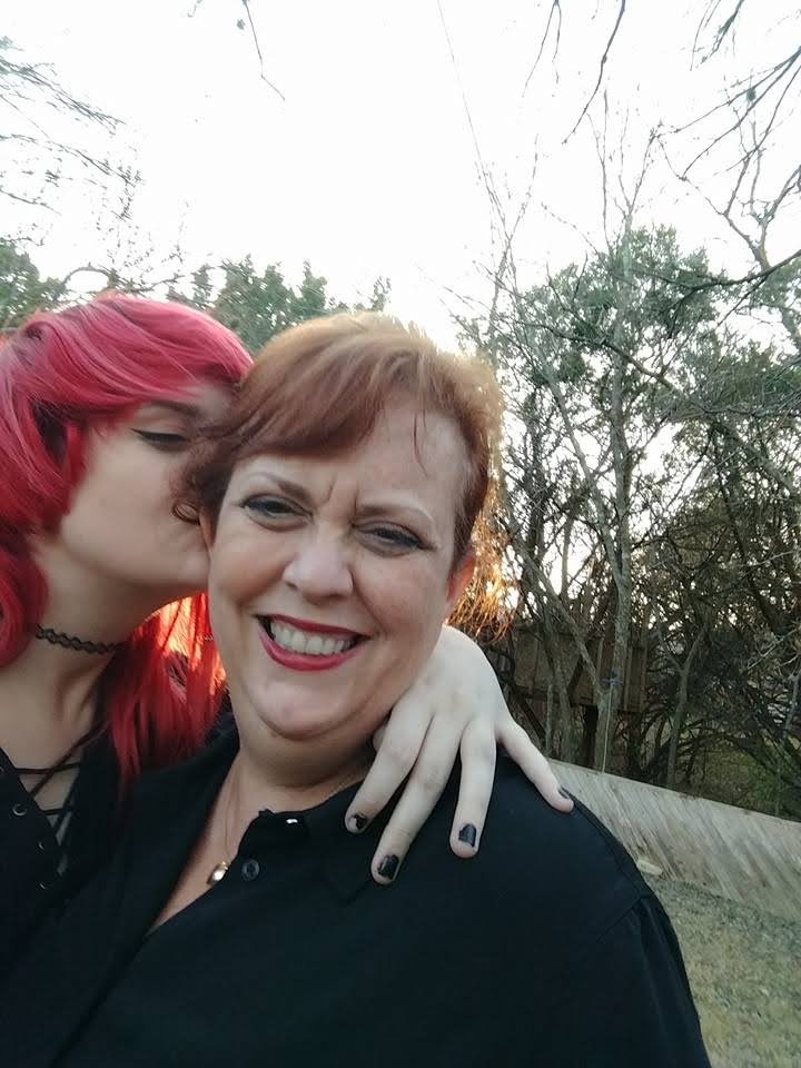 A woman with red hair and a woman with black hair share a moment, symbolizing the strength of diversity, the beauty of different brains, and embracing our differences.